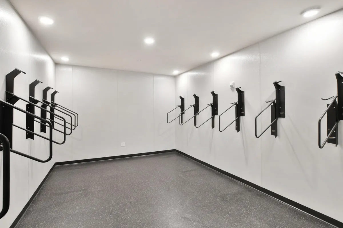 A minimalist and utilitarian bike storage area featuring organized racks and smooth walls, designed for storing and organizing bikes and adventure gear.